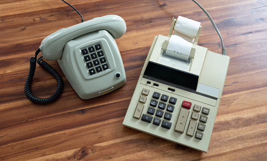 Old fashioned calculator and telephone on desk