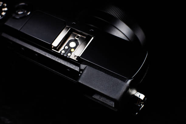 istock Black modern camera with lens on the black background. Close up. 1315325703