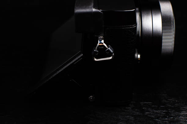 istock Black modern camera with lens on the black background. Close up. 1315325714
