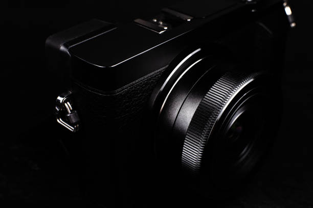 istock Black modern camera with lens on the black background. Close up. 1315325715