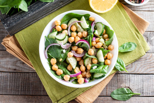 istock Spinach, cucumber, chickpeas, onions and lemon salad on a light table. Top view 1315325724