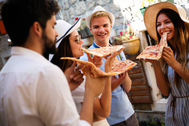 istock Group of friends eating pizza while traveling on vacation 1315329215