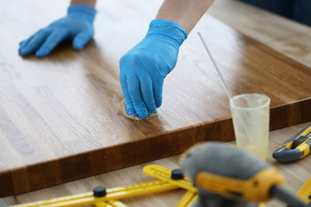 istock Gloved craftsman treats wooden covering with protective layer 1315330091