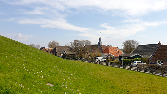 Paesens Moddergat, April, 19 - 2021: Small Dutch village at the bottom of the dike on a sunny spring day