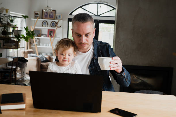 istock Father and daughter bonding while watching funny videos drinking coffee in kitchen 1315330577