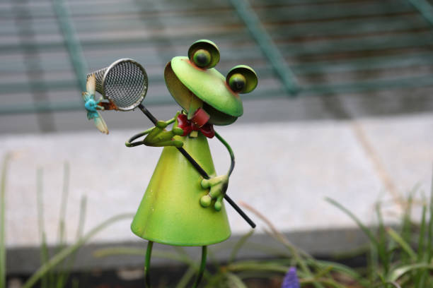 Decorative frog among plants in the garden.
