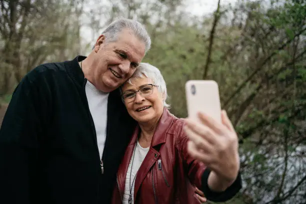 Elderly couple taking a selfie with their smartphone