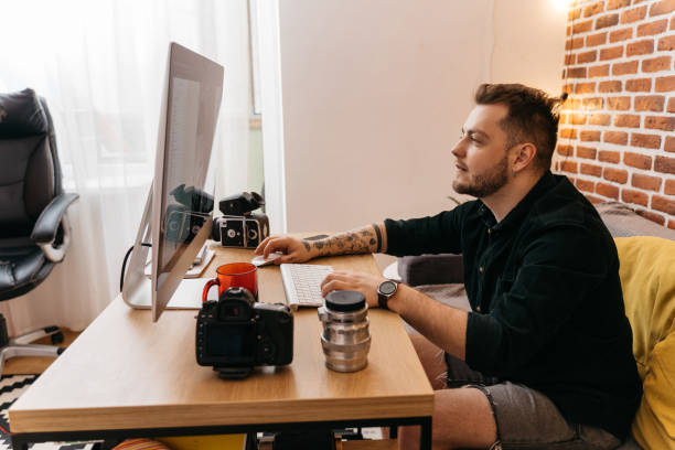 istock Yung caucasian man with photo camera and computer 1315340153