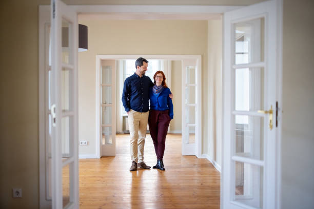 istock Smiling couple standing at empty new apartment 1315342485