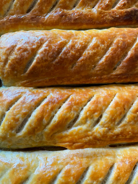 Full frame image of rows, golden brown, fresh crunchy sausage rolls, elevated view