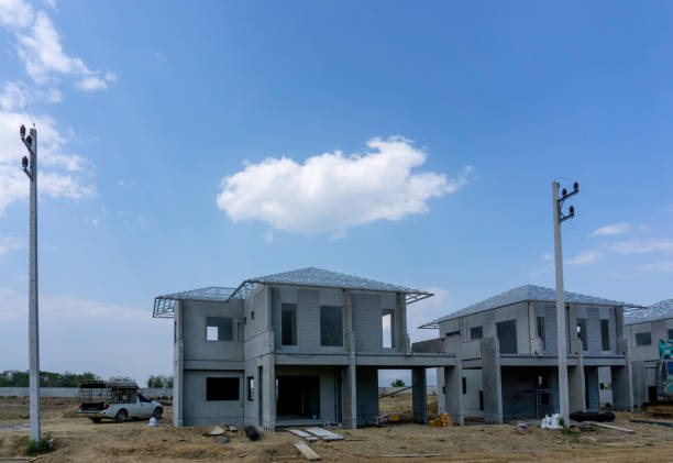 istock Construction progress in a real estate property project site, people are building the precast house on the brown land, electricity post in the front, working in a hot day under cloudy sky 1315344395