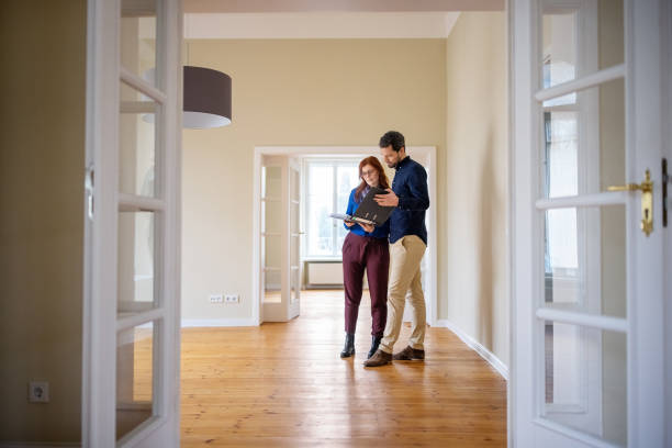 couples analysant des documents de maison avant d’acheter la nouvelle maison - location immobilière photos et images de collection