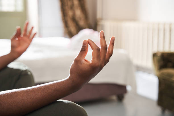 mann hält hände an der mudras-geste, während er in yoga-haltung sitzt und meditiert - mudras stock-fotos und bilder