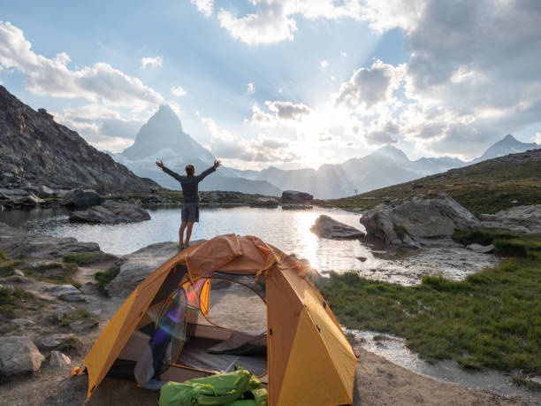 istock Man camping on mountain top, arms outstretched 1315352292