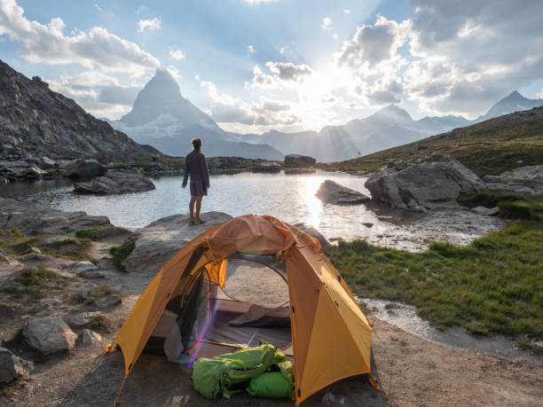 istock Man camping near alpine lake, sunset 1315352367