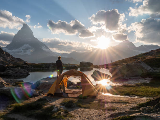 istock Man camping near alpine lake, sunset 1315352453