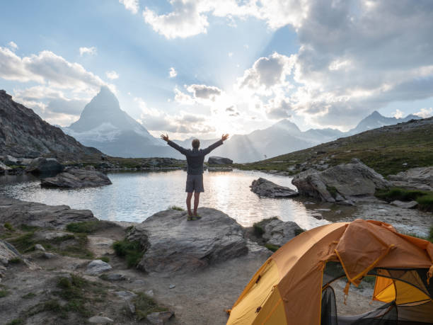 istock Man camping on mountain top, arms outstretched 1315352532