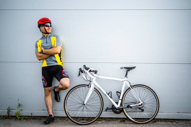 istock Young Man with sport Bicycle on white wall 1315352538