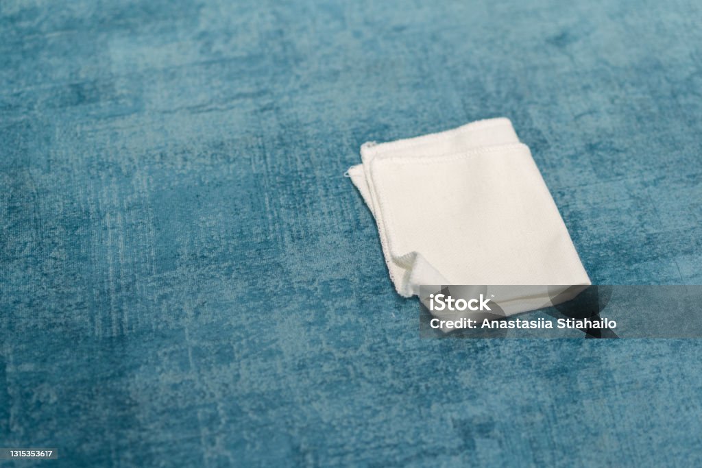 Woman cleaning a blue sofa with white cloth. Sofa cleaning. Woman cleaning a blue sofa with white cloth. Sofa cleaning. Removing stains. Cleaning Stock Photo