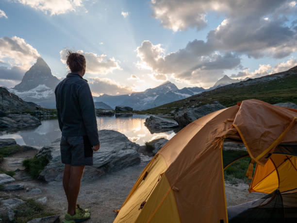 istock Man camping near alpine lake, sunset 1315353840