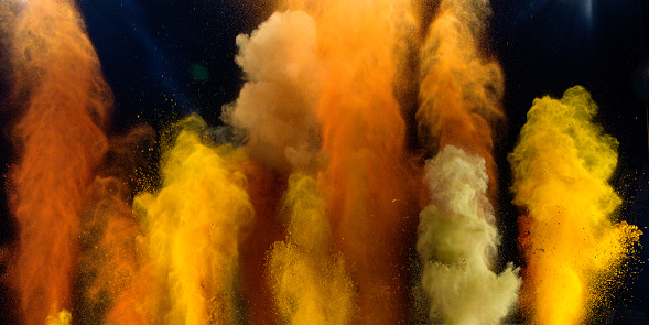 Colourful spices exploding into the air against black background.