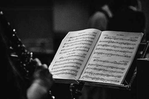 Notation of Ave Maria sitting on a note stand and being played on a wind instrument