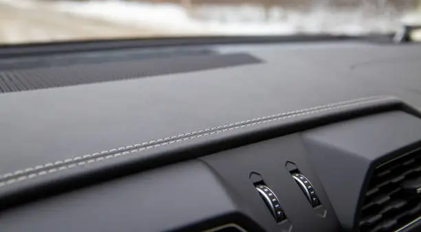 white trim on the black leather interior of a premium modern car. close-up. selective focus. no people