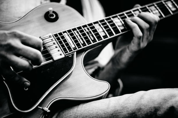 istock Man playing guitar in black and white 1315358774