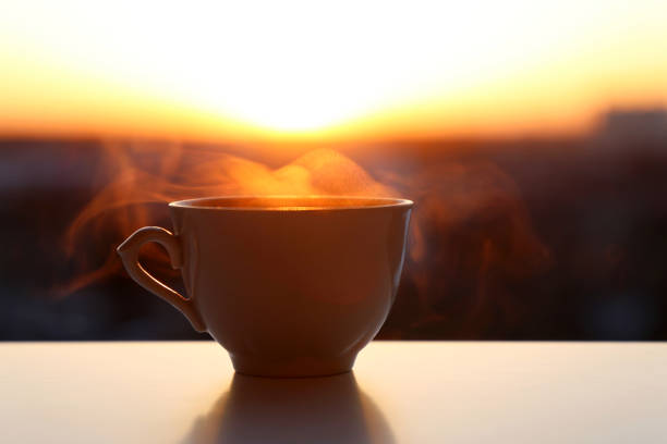 istock Hot coffee cup with smoke on sunrise background 1315359768