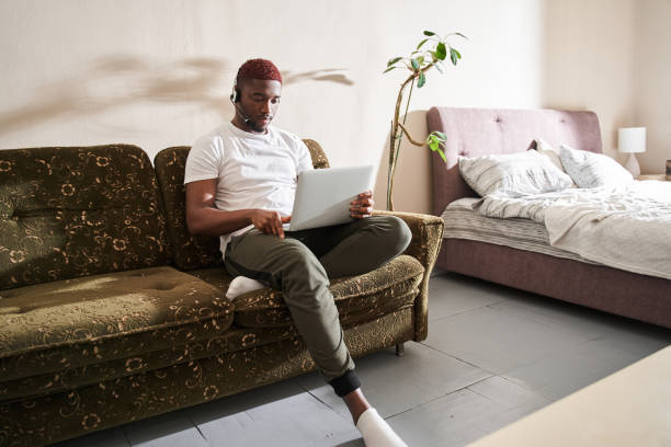 istock Man sitting on sofa at home and working on laptop online 1315366249