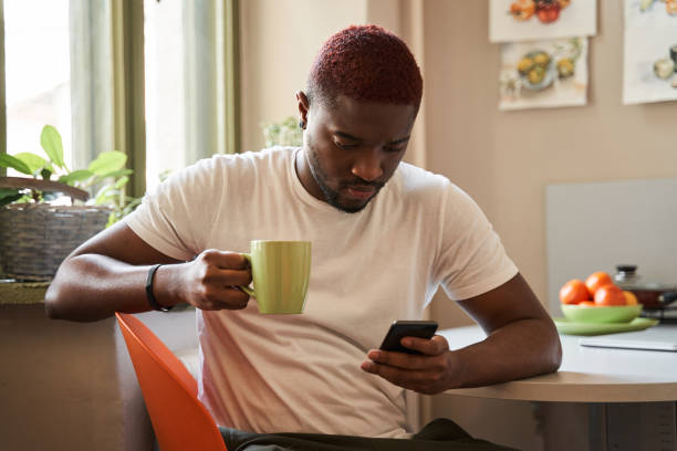 istock Man with stylish haircut holding his smartphone and checking messages 1315366362
