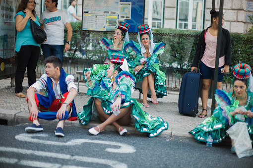 Lisbon, Portugal - June 12, 2014: Women dressed in traditional folklore costumes wait at a bus stop to parade in Lisbon downtown during this city celebrations of the Popular Saints.