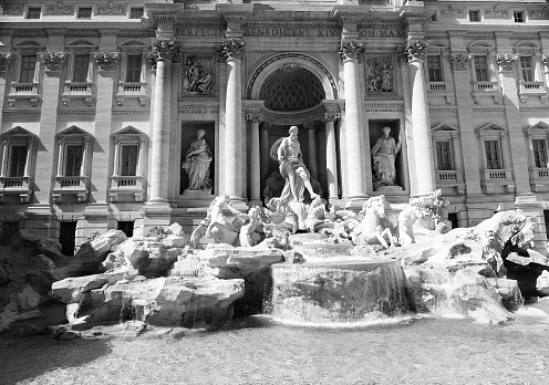 ancient monument called the Trevi Fountain in central Rome with the statue of Neptune without tourists because in black and white