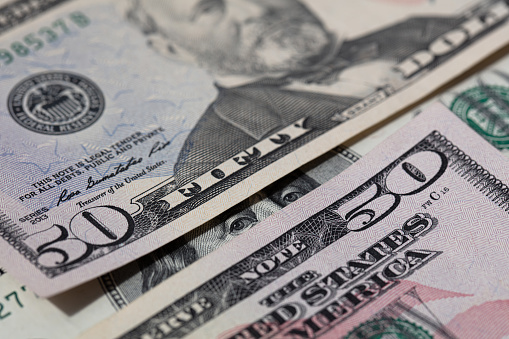 Benjamin Franklin peeking through 50 dollar banknotes for design purpose