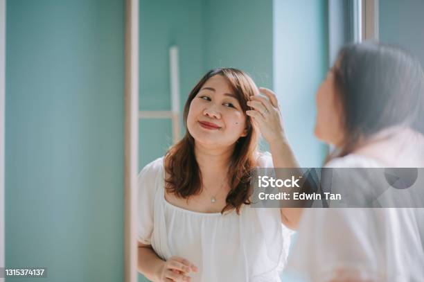 Asian Chinese Body Positive Woman Enjoying Her Weekend At Home Makeup In Front Of Mirror Stock Photo - Download Image Now