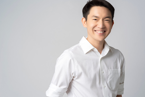 studio portrait of an attractive young asian businessman white shirt half body isolated on grey background