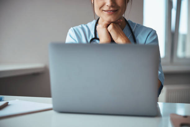 istock Smiling female doctor using laptop in clinic 1315374668