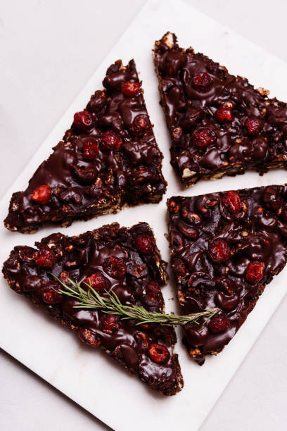 istock Mosaic Chocolate and Biscuit Cake with Nuts and Dried Cherries on white marble board. Chocolate and cookie dessert. Christmas delicious treat 1315376662