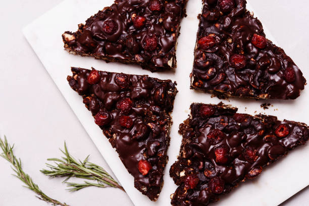 istock Mosaic Chocolate and Biscuit Cake with Nuts and Dried Cherries on white marble board. Chocolate and cookie dessert. Christmas delicious treat 1315376669