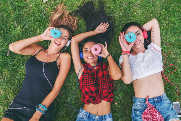 istock Attractive women making funny faces with colorful donuts 1315376890