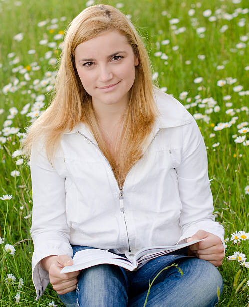 istock Beautiful young woman reading a book 131537765