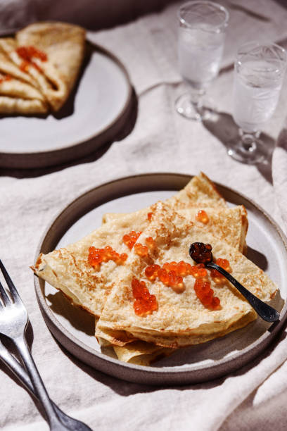 crepes tradicionais russos ou panquecas com caviar vermelho em pratos cinzas e copos de vodca gelada - appetizer caviar gourmet blini - fotografias e filmes do acervo