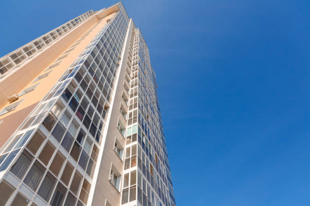 Facade of a new tall building against the blue sky, bottom view. Construction industry
