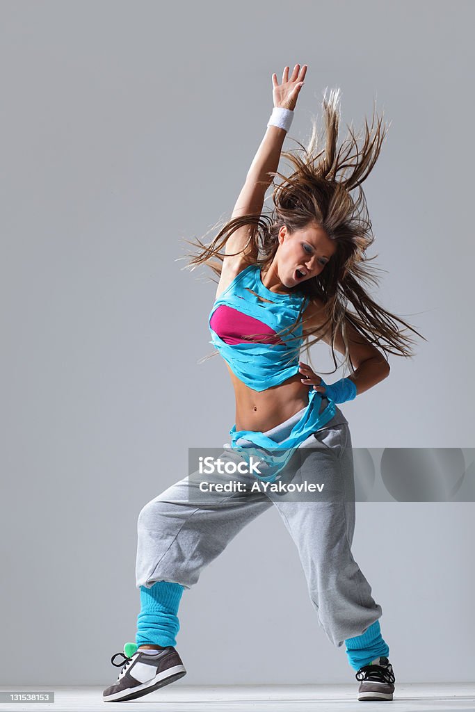Woman wearing bright blue and pink cropped shirt dancing modern style dancer posing on studio background Activity Stock Photo