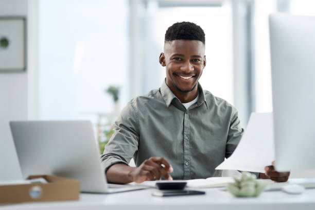 schuss eines jungen geschäftsmannes, der an einem computer in einem büro arbeitet - desk men sitting computer stock-fotos und bilder