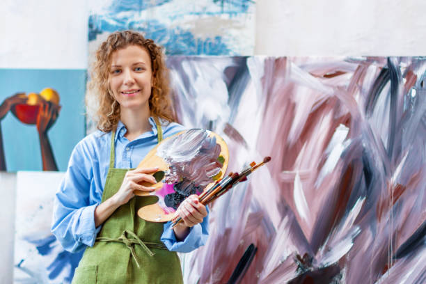 istock Artist standing at her workshop, surrounded with paints, 1315385606