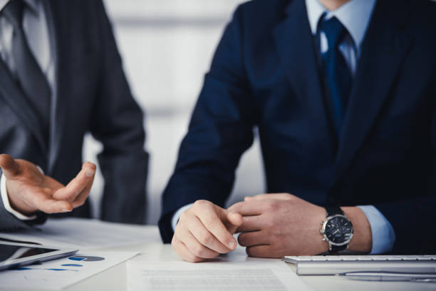 istock Business people using computer while working together in modern office. Unknown businessman or male entrepreneur with colleague at workplace. Teamwork and partnership concept 1315389172