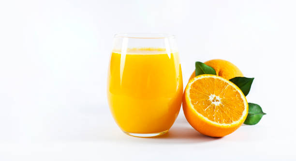 Glass of fresh orange juice with fruits cut in half and sliced with green leaf isolated on white background, clipping path stock photo