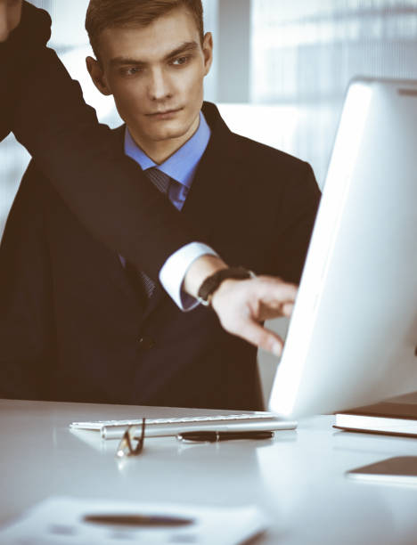 istock Two businessmen discussing questions at meeting in a modern office, using a computer. Headshot at negotiation or workplace. Teamwork, partnership and business concept 1315390517