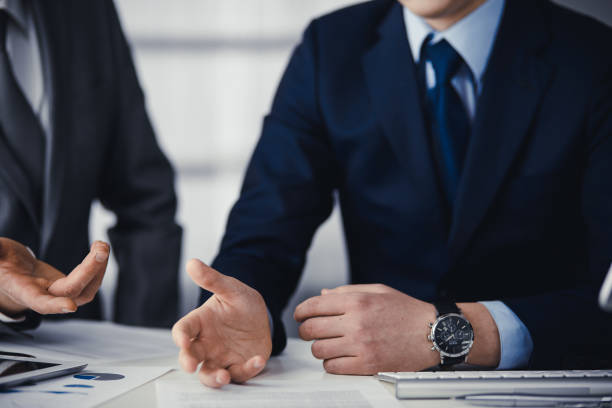 istock Business people using computer while working together in modern office. Unknown businessman or male entrepreneur with colleague at workplace. Teamwork and partnership concept 1315390550